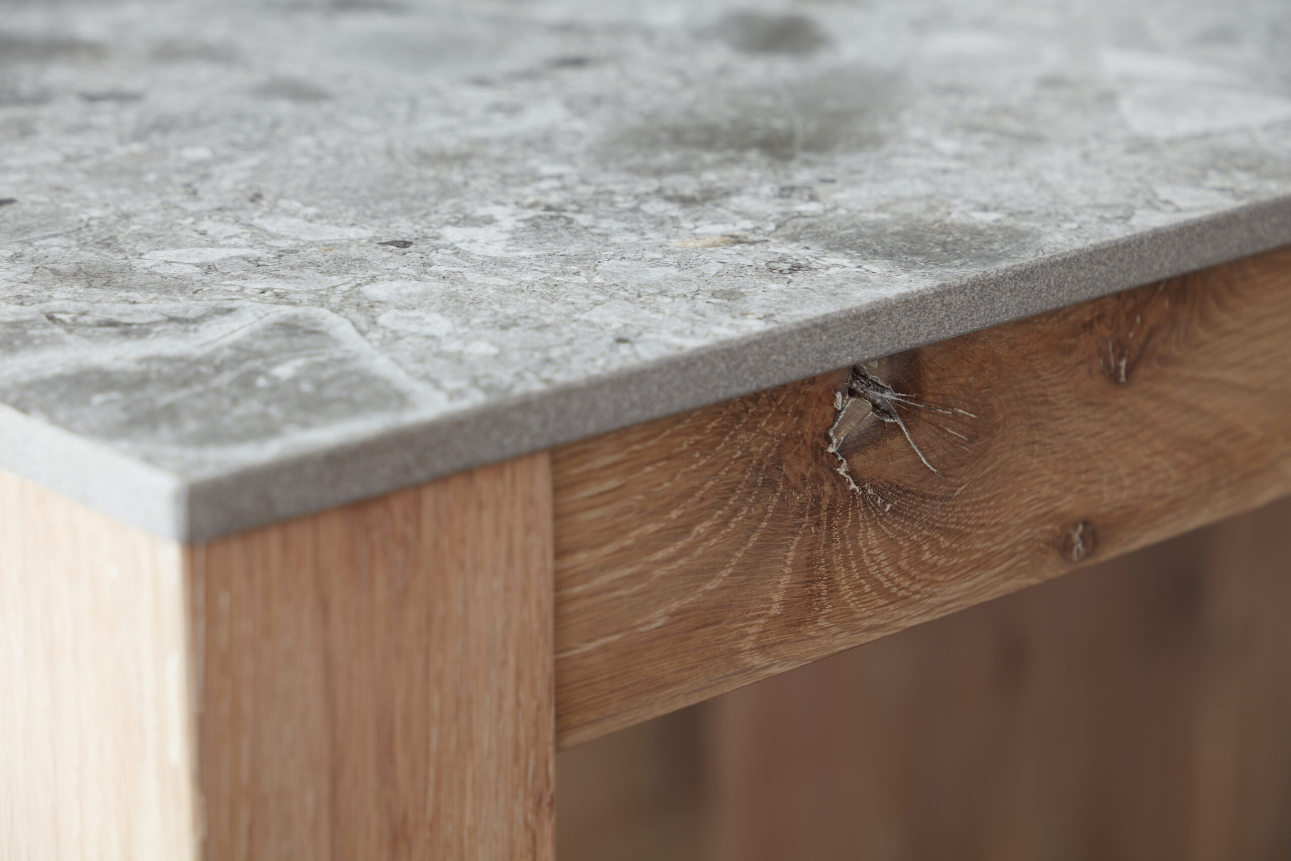 Reclaimed oak grain meeting a stone worktop, up close